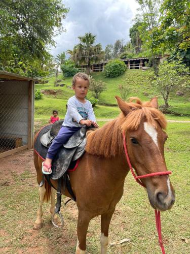 a little child sitting on top of a horse at Pousada Atibaia in Atibaia