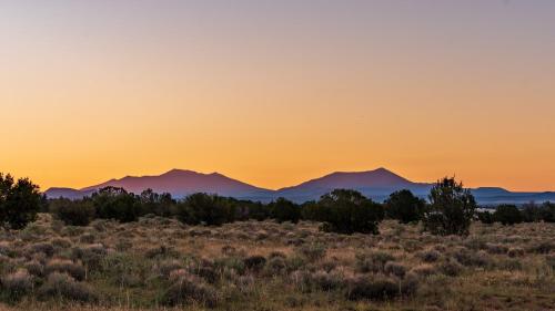 a sunset in the desert with mountains in the background at The Grand Canyon Headquarters in Valle