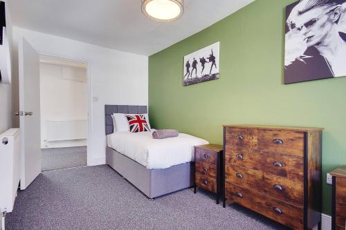 - une chambre avec un lit et une commode en bois dans l'établissement The Loft, à Bournemouth