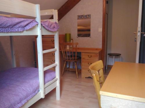 a room with two bunk beds and a desk at CHALET du LAC in Saint-Rémy-sur-Durolle