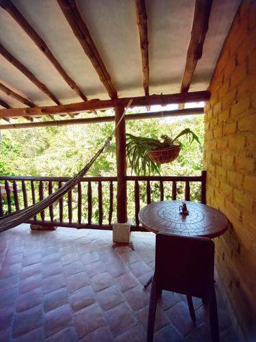 a room with a table and a balcony at Casona CHARA in Barichara