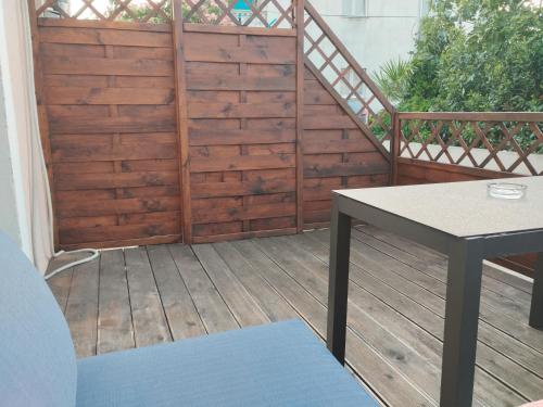 um deque de madeira com uma mesa e uma cerca de madeira em Apartments Blanca em Vodice