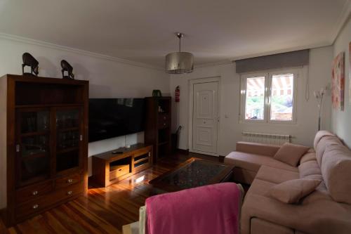 sala de estar con sofá y TV de pantalla plana en APARTAMENTO COSTA CANTABRIA, en Cuchía