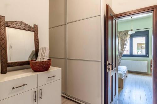 a bathroom with a mirror and a white cabinet at 50 steps from the sea. in Gournes