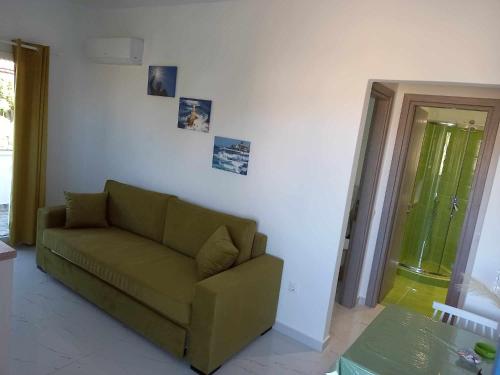 a living room with a green couch and a table at levante studios Αndros in Ménites