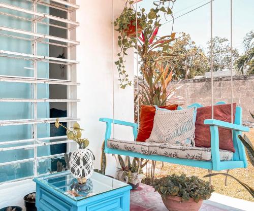 a swing on a porch with plants at Casa Momo Bacalar in Bacalar