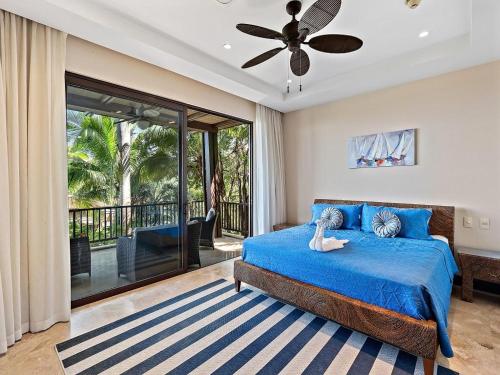 a bedroom with a blue bed and a balcony at AP-10C Azul Paraiso in Ocotal
