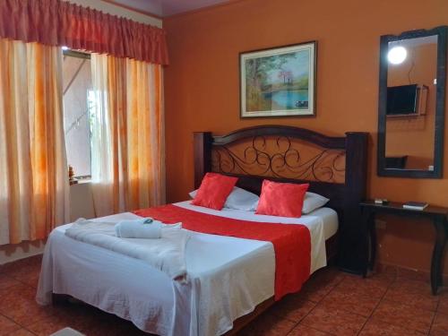 a bedroom with two beds with red pillows at Hotel Torre Fuerte in Venecia