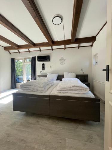 a bedroom with a large bed in a room at Unieke Twentse boerderij - 4 bedrooms & huge private garden in Den Ham