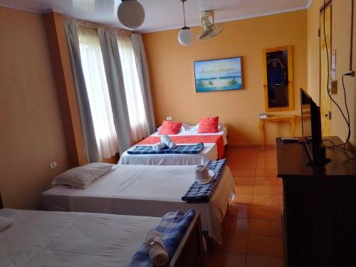 a hotel room with two beds and a television at Hotel Torre Fuerte in Venecia