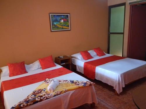 a bedroom with two beds with red and white sheets at Hotel Torre Fuerte in Venecia