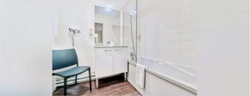 uma casa de banho com uma cadeira azul e um espelho. em T2 Toulouse centre em Toulouse