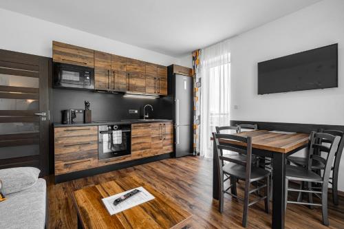 a kitchen and dining room with a table and chairs at J-H APARTMÁNY HORSKÝ RESORT BUKOVÁ HORA - 100 m od LANOVKY in Červená Voda