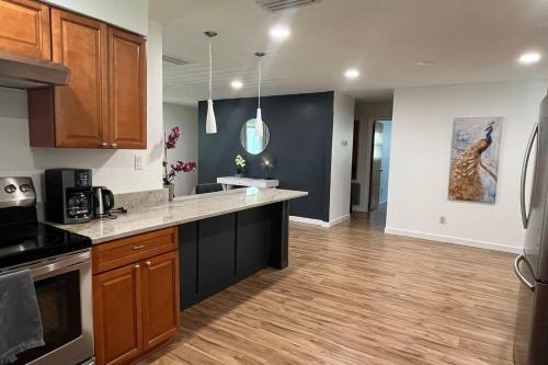 a kitchen with wooden cabinets and a counter top at LuxCoral - 4 Min walk to beach! in Cape Canaveral