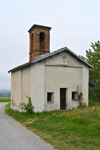 an old white building with a chimney on the side of a road at CASCINA BINELLO appartamento B in Murazzano