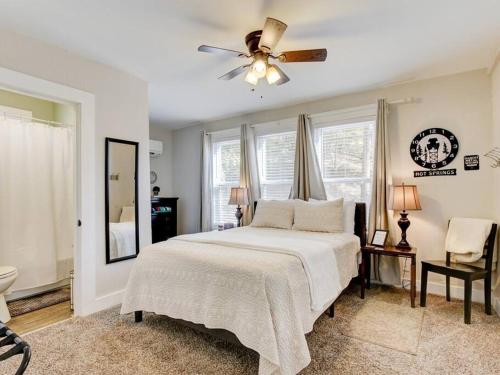 a bedroom with a bed and a ceiling fan at Cedar Blossom Bungalow is a cozy getaway with a 5 minute walk to downtown! in Hot Springs