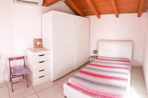 a bedroom with a bed and a chair and a dresser at La Villa di Bambi in Vanzago