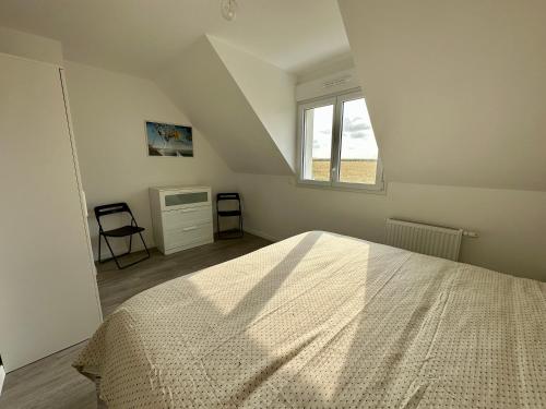 biała sypialnia z łóżkiem i oknem w obiekcie La Belle Envolée w mieście Wissant