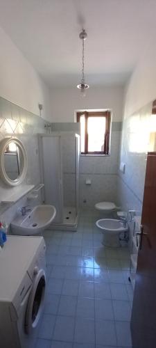 Baño blanco con 2 lavabos y 2 aseos en Casa Pako en Tortora