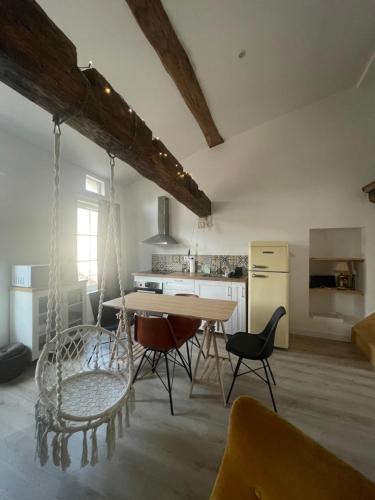 uma cozinha com mesa e cadeiras num quarto em La Pause Saintaise chez Sandrine em Saintes