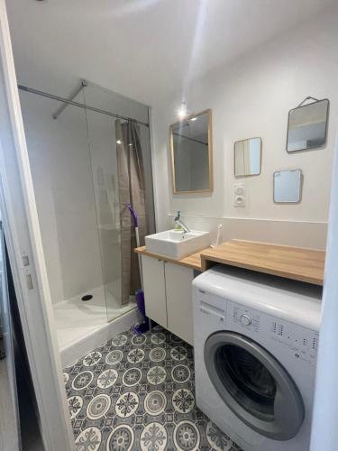 a bathroom with a washing machine and a sink at La Pause Saintaise chez Sandrine in Saintes