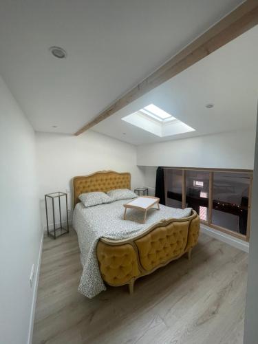 a bedroom with a large bed and a skylight at La Pause Saintaise chez Sandrine in Saintes