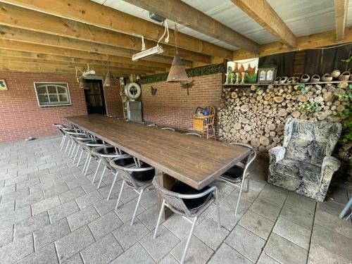 einen großen Holztisch und Stühle in einem Zimmer in der Unterkunft completely renovated back part of a farm in Uden