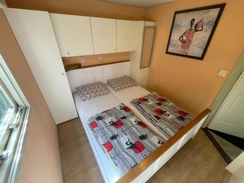 a small room with a bed with shoes on it at Quaint Chalet in Uden with Terrace in Uden