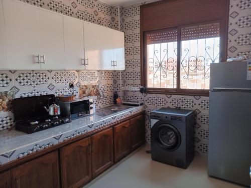 a kitchen with a refrigerator and a washing machine at Résidence Jannat in Ouarzazate