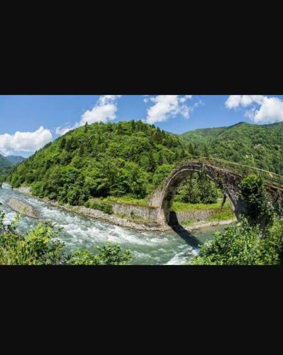 an old bridge over a river in a mountain at Ayder Paradise Otel in Ayder Yaylasi