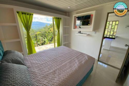 a bedroom with a bed and a large window at Mountain View posada campestre in Vergara