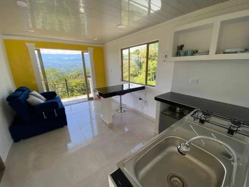 a kitchen with a sink and a couch in a room at Mountain View posada campestre in Vergara