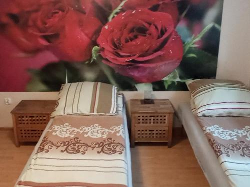 two beds in a room with a flower on the wall at Agroturystyka Kwatery pracownicze Noclegi Rybno Mazury in Rybno