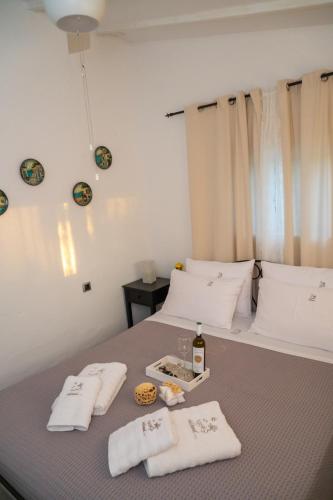 a bed with two towels and a tray of food on it at Island house in Psakoudia