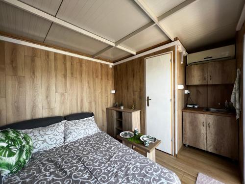 Schlafzimmer mit einem Bett und Holzwänden in der Unterkunft Splav na reci Savi in Ostružnica