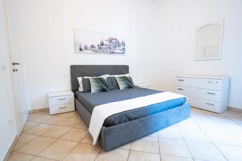a bedroom with a bed with a blue and white bedspread at Appartamenti Empoli-Vinci in Empoli