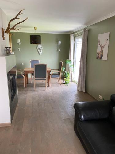 a living room with a couch and a table and chairs at Le doux refuge in Bouillon