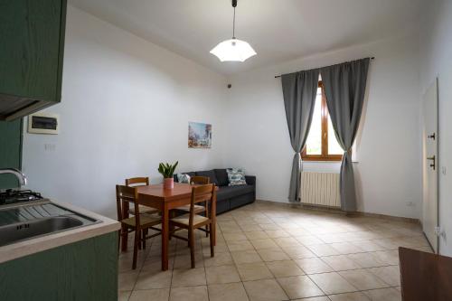 a kitchen and living room with a table and a couch at Appartamenti Empoli-Vinci in Empoli
