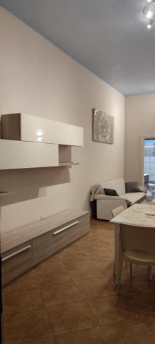 Una cocina y una sala de estar con una mesa y un sofá. en Residence Salento, en Palmariggi