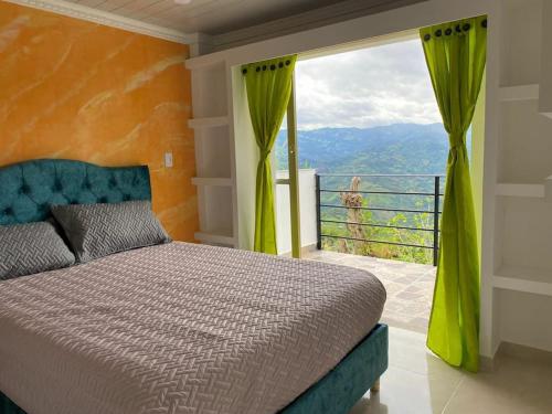 a bedroom with a bed and a large window at Mountain View posada campestre in Vergara