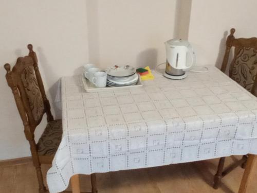 a table with a white table cloth and a tea set at Agroturystyka Kwatery pracownicze Noclegi Rybno Mazury in Rybno