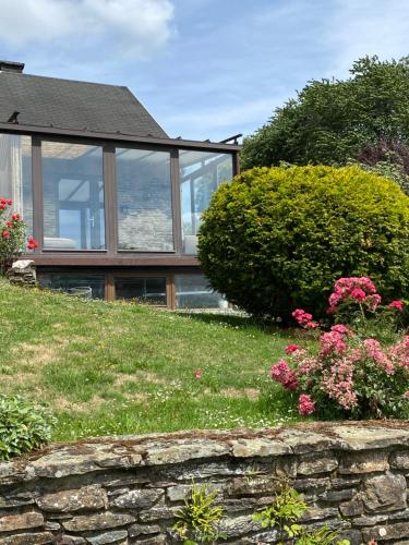a house on a hill with a stone wall at Le doux refuge in Bouillon