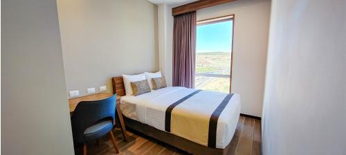 a bedroom with a bed and a large window at FUJITAYA Querétaro in Querétaro