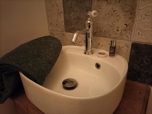 um lavatório branco com uma torneira na casa de banho em Gîte Ti Laouen em Plélo