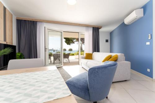 a living room with a white couch and a blue chair at Superior Seaview Apt. with Pool in Umag