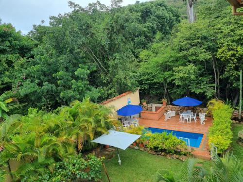 an aerial view of a backyard with a swimming pool and blue umbrellas at El Retiro 104 in Barichara