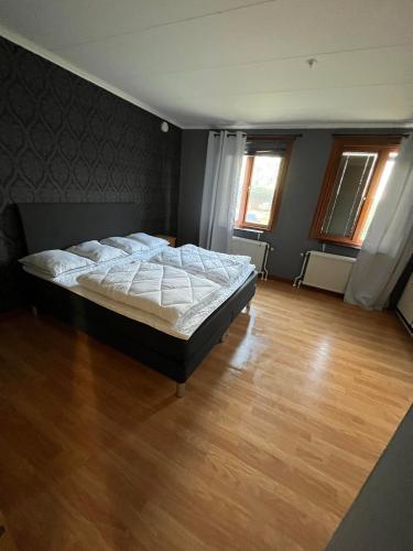 a bedroom with a large bed in a room with wooden floors at Vetlandavägen 37 C in Målilla