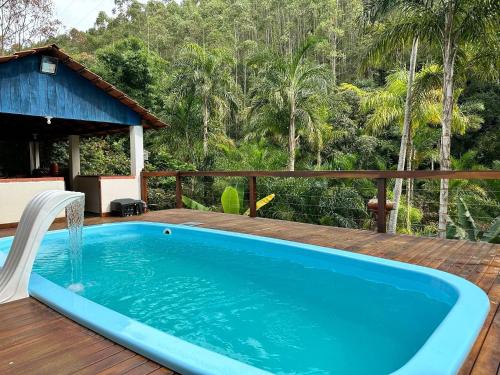 una piscina en una terraza con una fuente de agua en Sítio incrível 4Q c/ piscina e área de churrasco, en Vítor Hugo