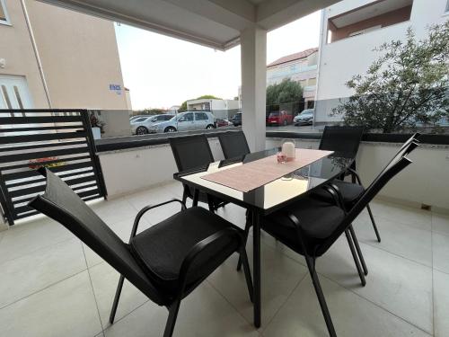 a table and chairs sitting on a balcony at Apartments Ivana in Sveti Filip i Jakov