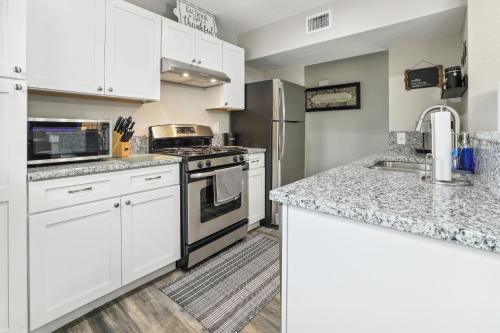 a kitchen with white cabinets and granite counter tops at Spacious San Antonio Retreat with Private Patio! in San Antonio